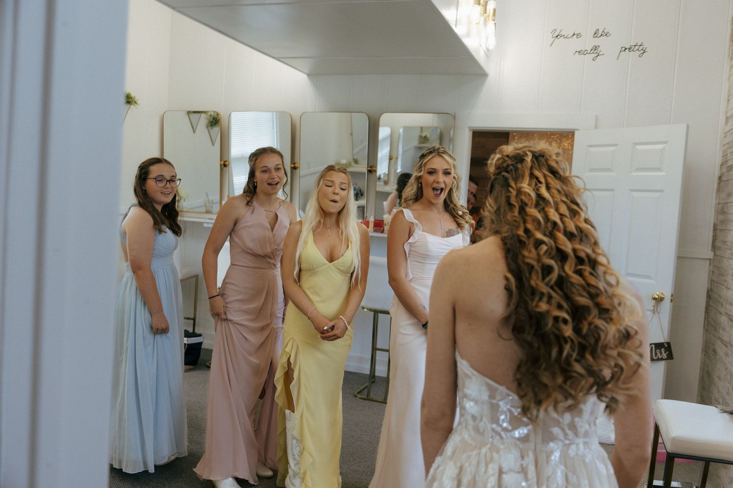 girls getting first look at bride with surprised looks