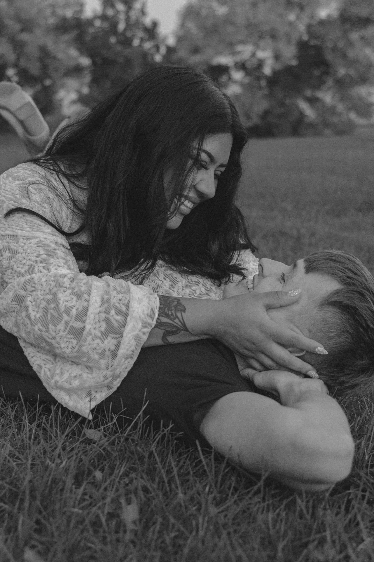 couple smiling and laughing together in grassy field