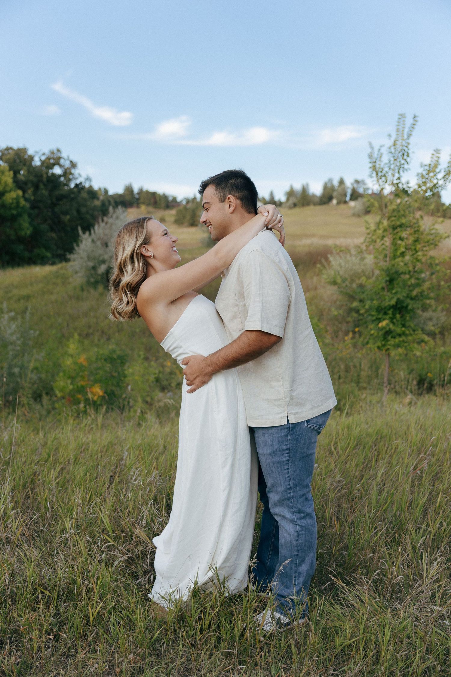 A romantic moment captured between a couple in a scenic hillside setting.