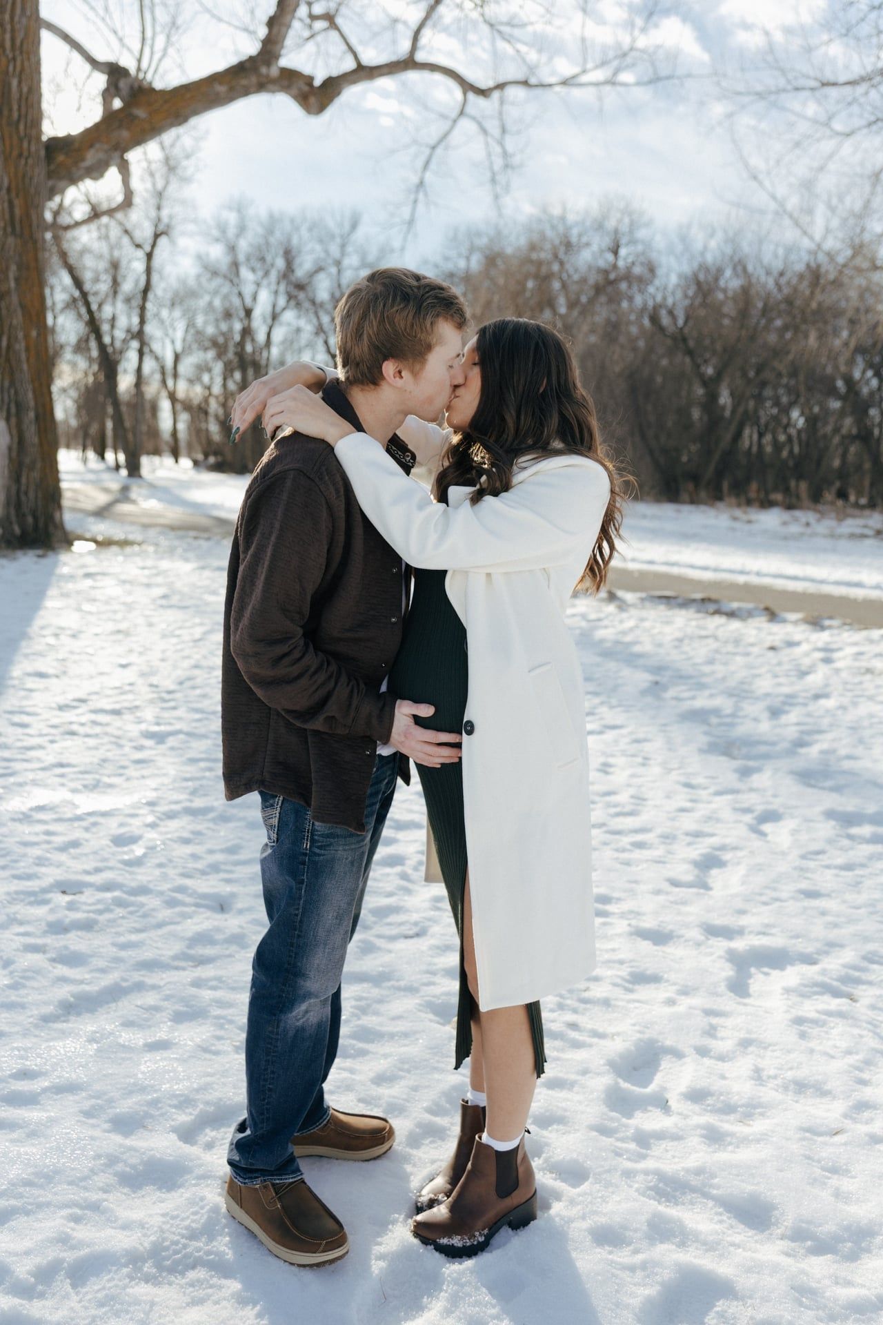 Couple kissing in snowy park in Bismarck