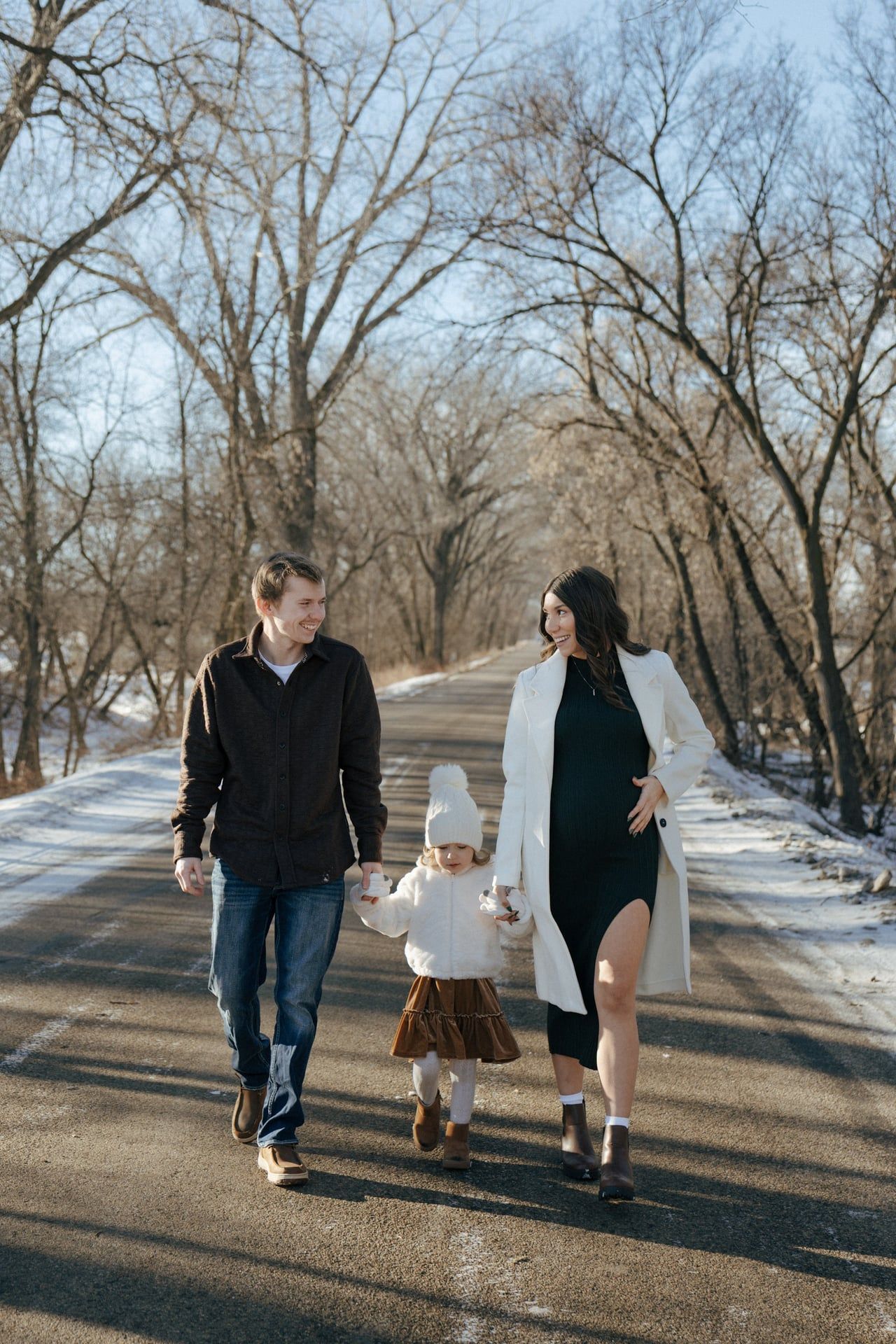 photos of family walking holding hands in snowy trees in Bismarck