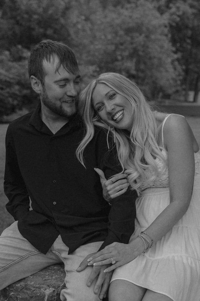 couple smiling looking at each other in black hills for engagement session