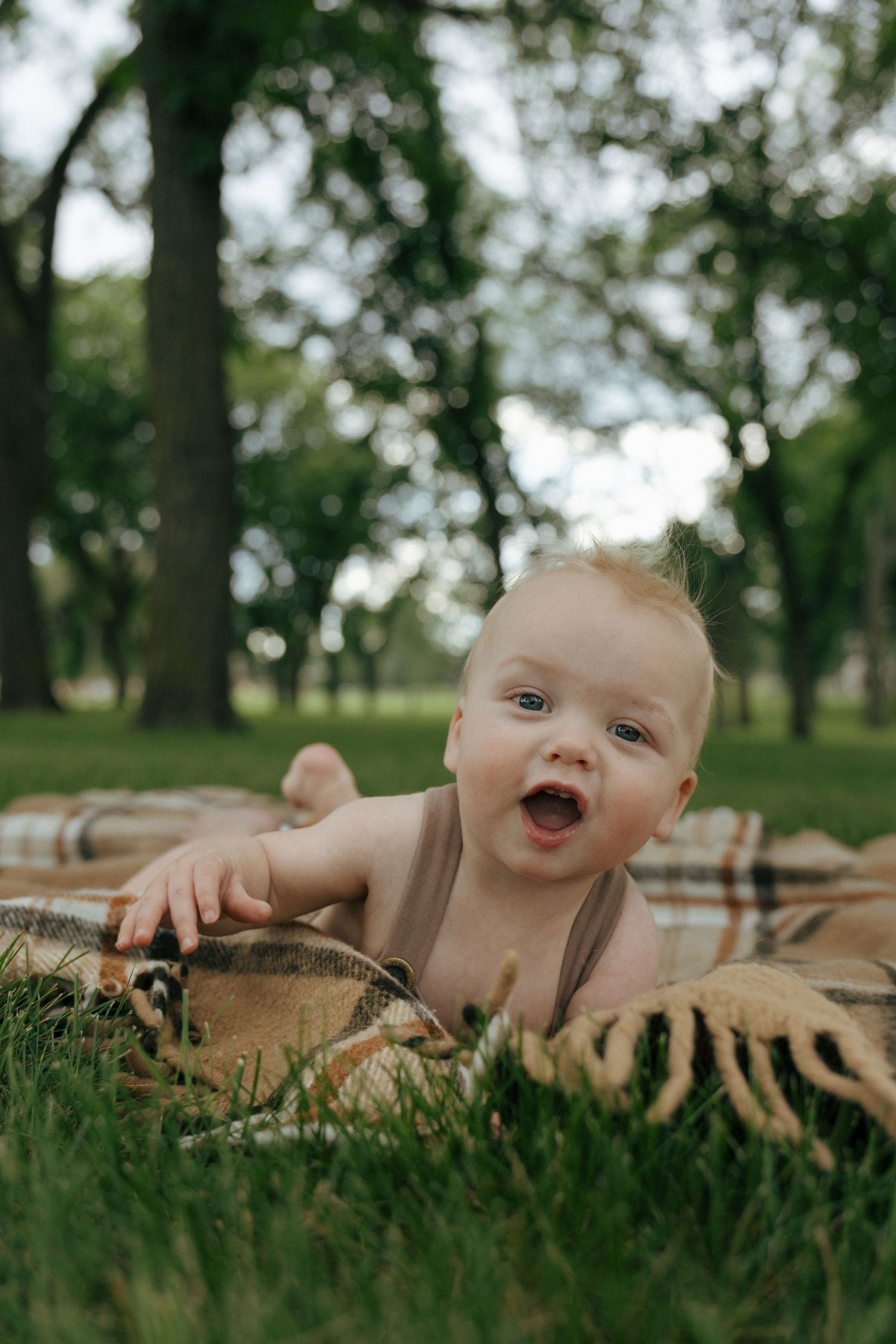 baby crawling towards camera on blanket on the capitol grounds in Bismarck North Dakota