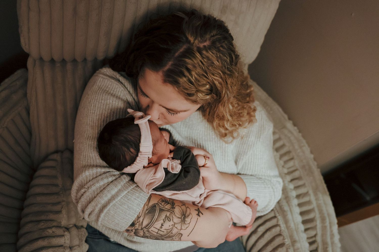 mom kissing newborns head