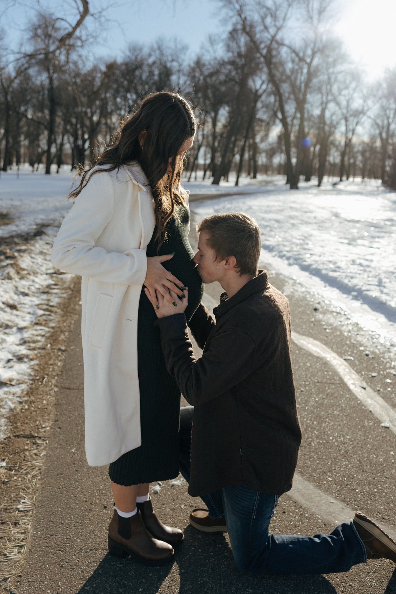 man kissing belly bump for maternity session in Bismarck