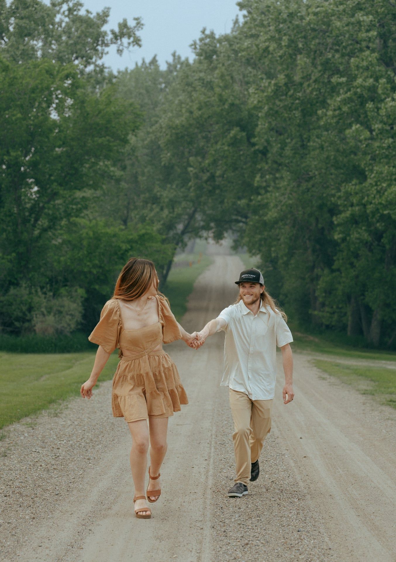 couple running on dirt road together in Bismarck