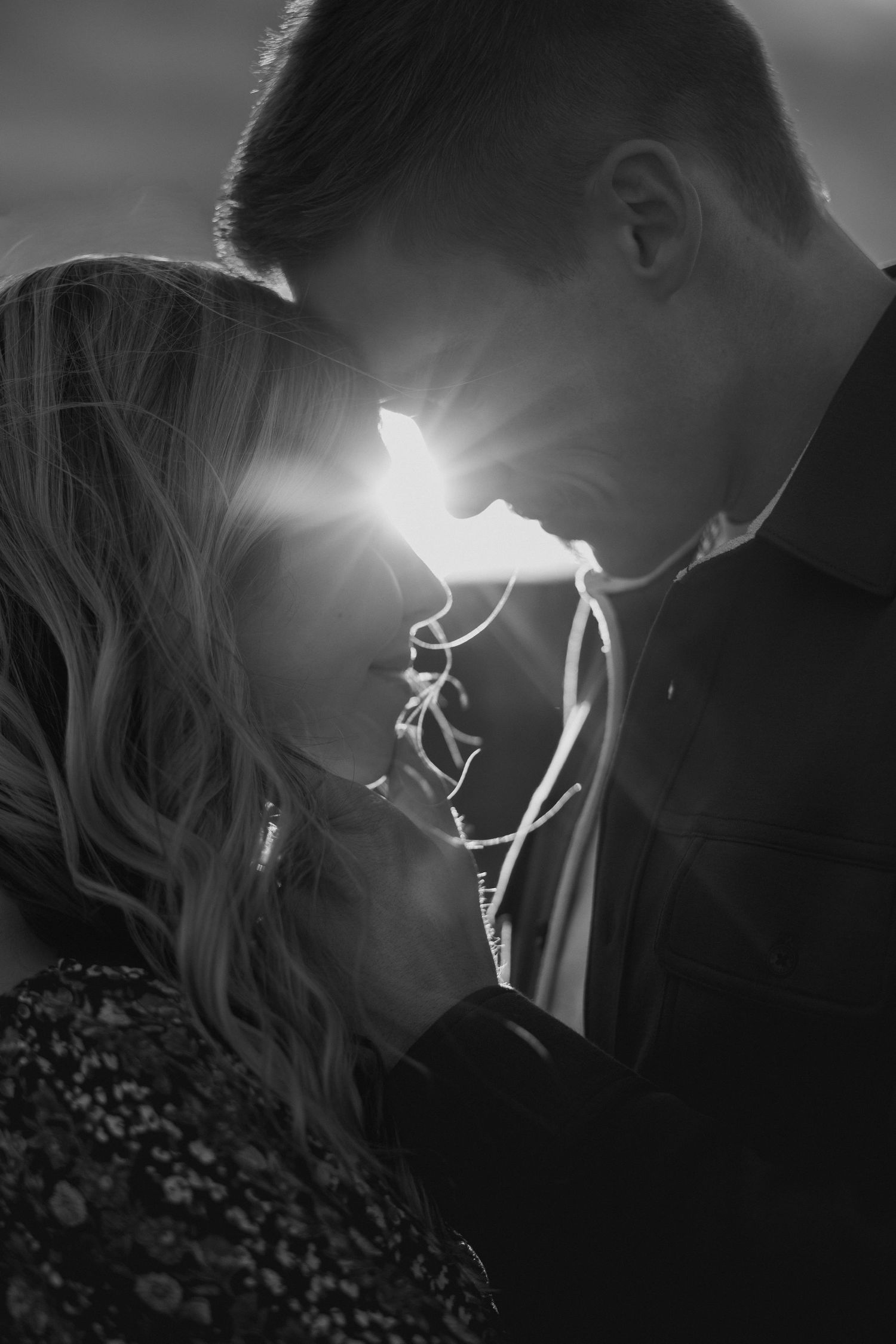 Dramatic backlit silhouette of a romantic moment with sun flare effect.