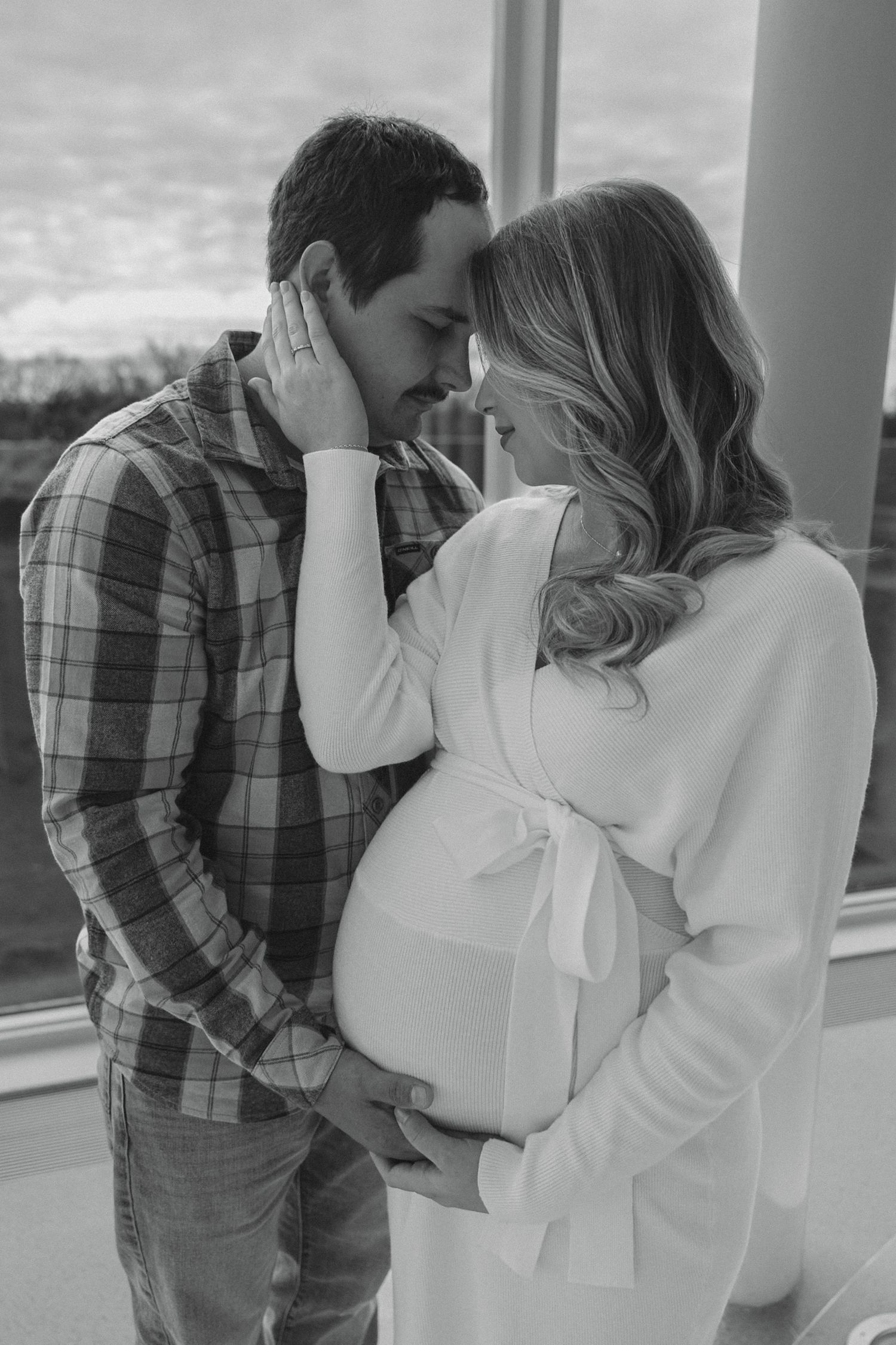couple holding each other close for maternity session photos