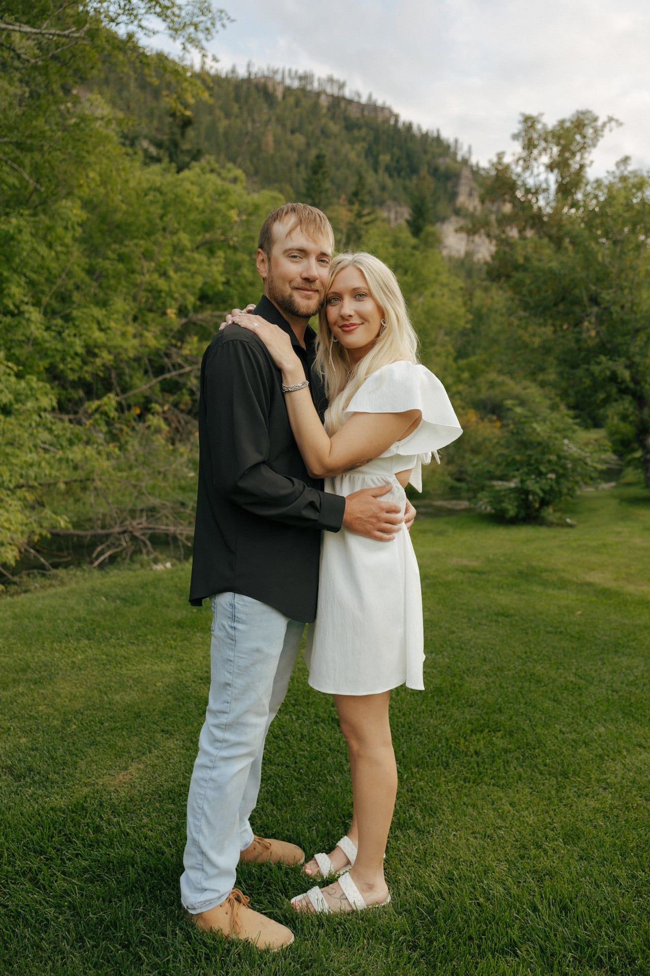 couple smiling at camera in black hills for engagement session