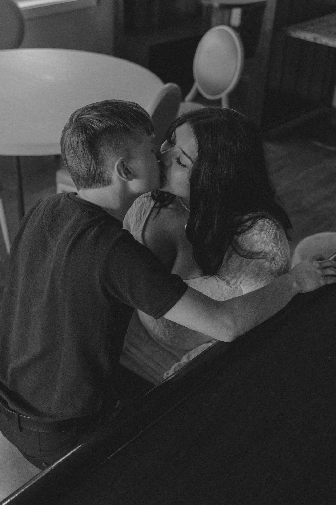 couple kissing at bar top for engagement in Bismarck