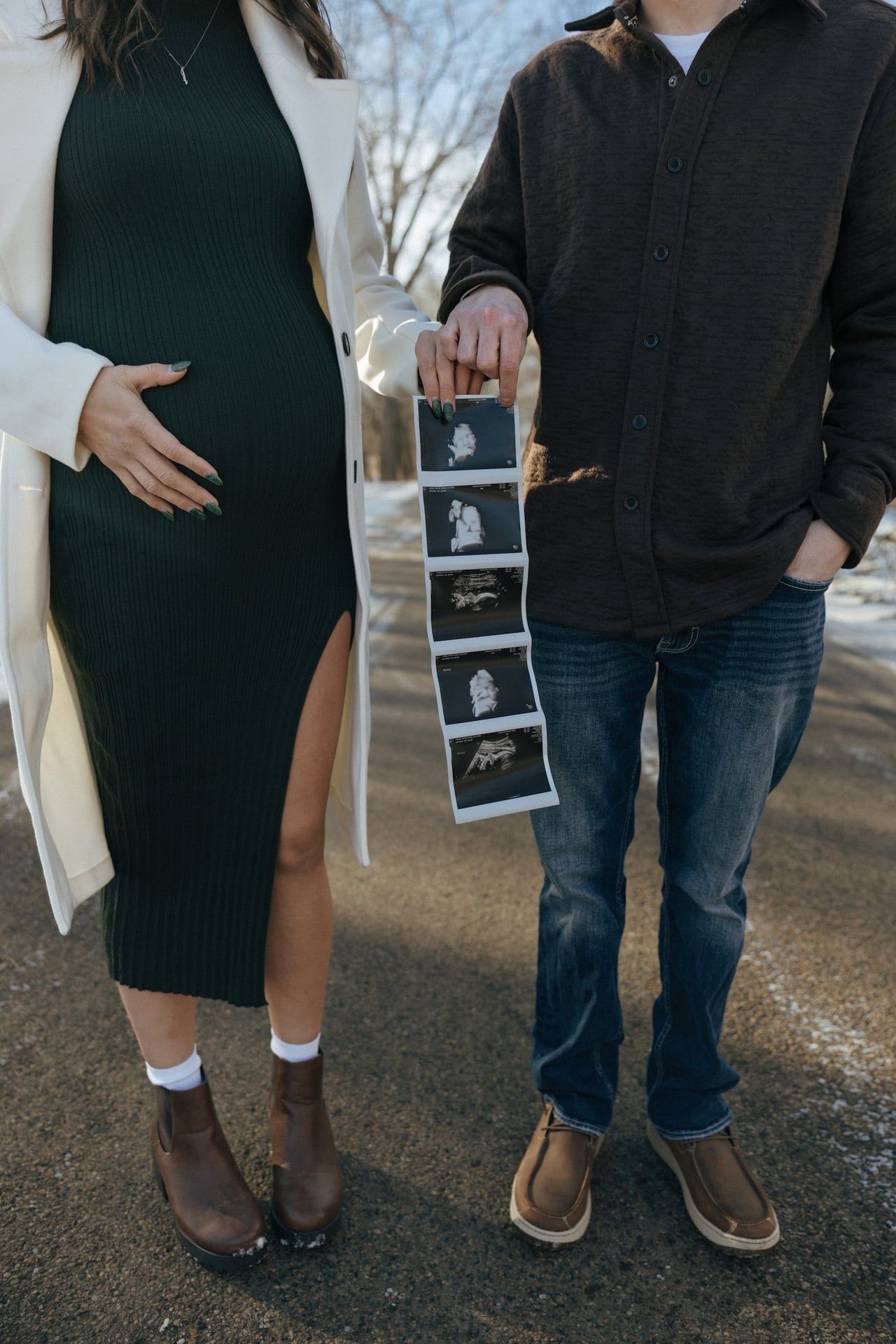 Couple in snowy trees in Bismarck with ultrasound photos