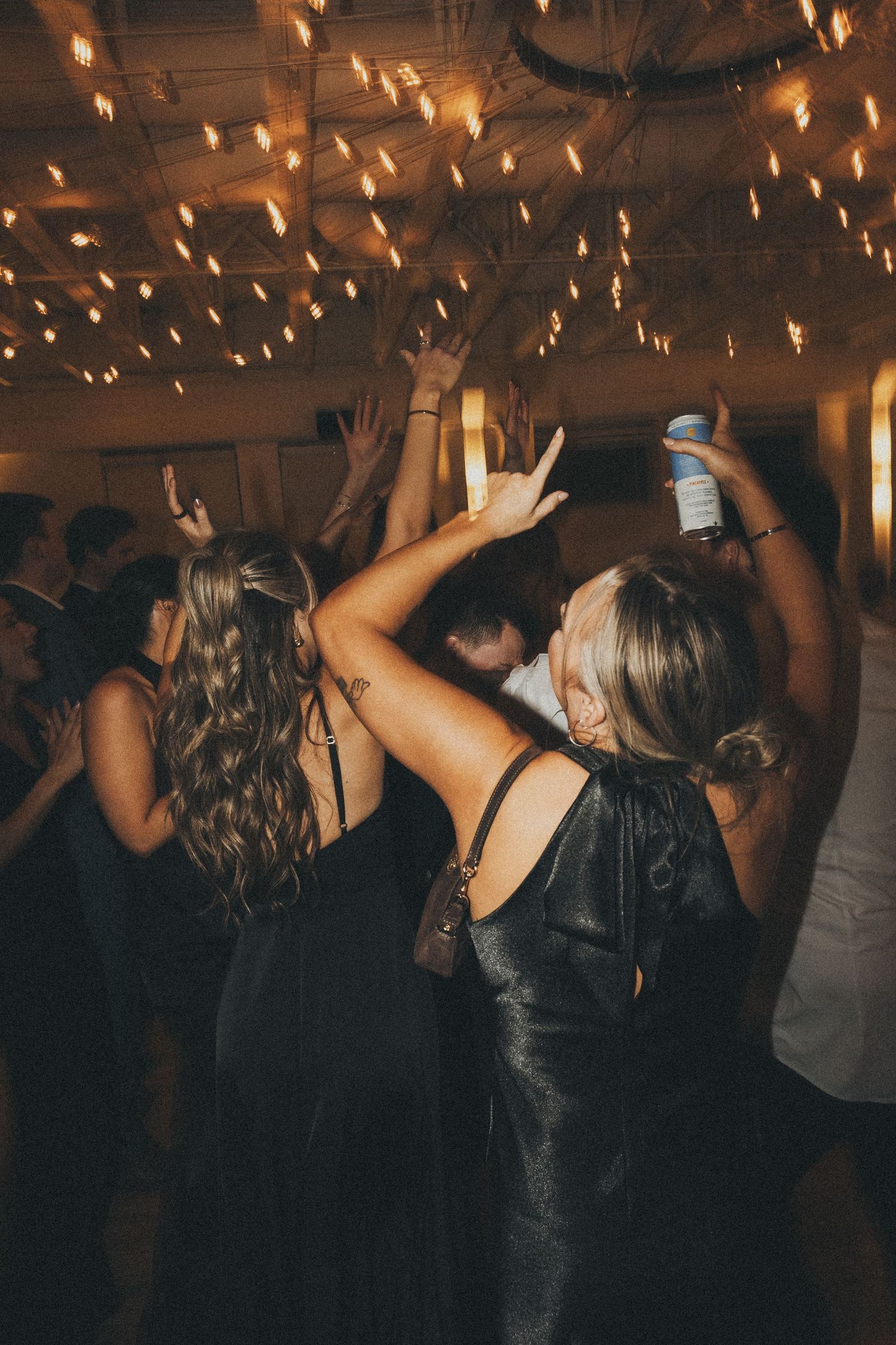 reception party with people dancing and their drinks celebrating the couple on their wedding night