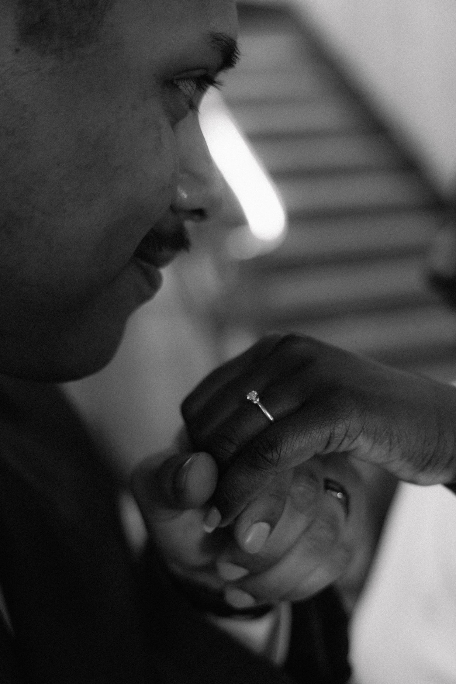 Close-up black and white shots of hands with wedding rings.