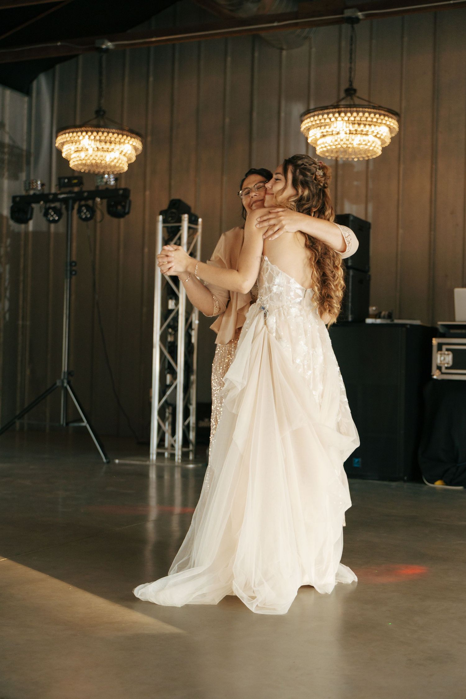 Dancing in an elegant venue with crystal chandeliers overhead.