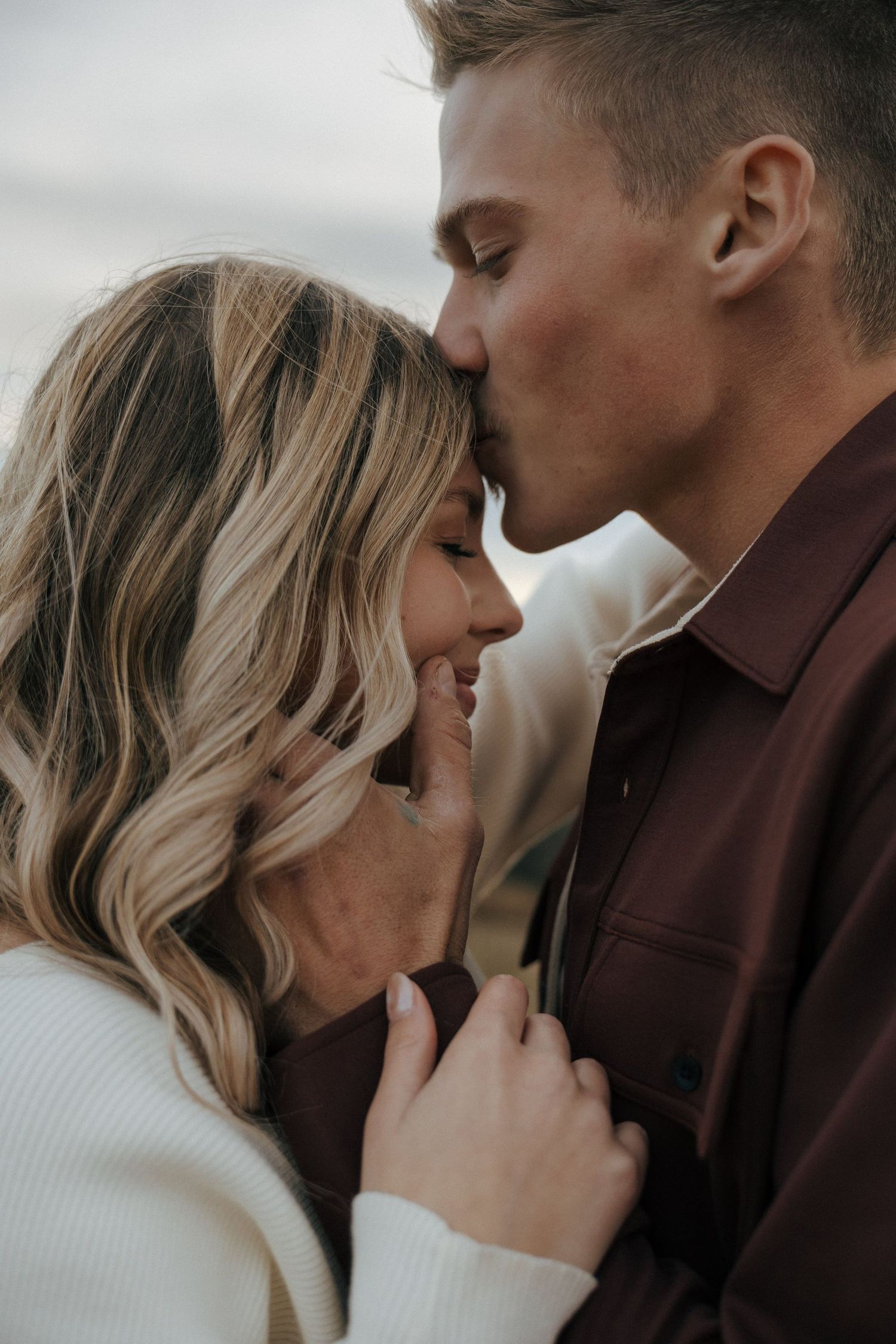 A romantic close-up photograph of a couple embracing and sharing an intimate moment.