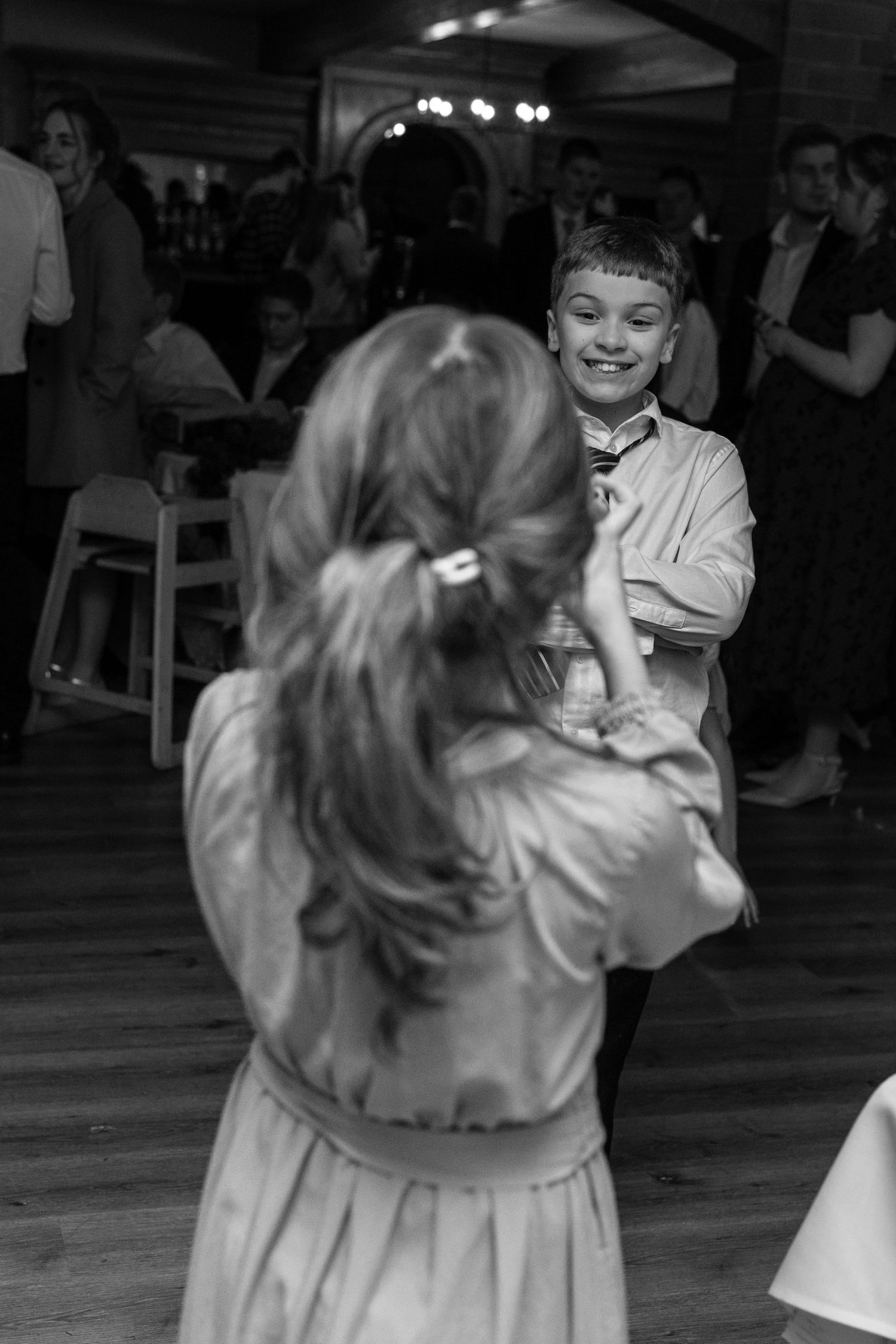Black and white photo of joyful dancing at a wedding reception.
