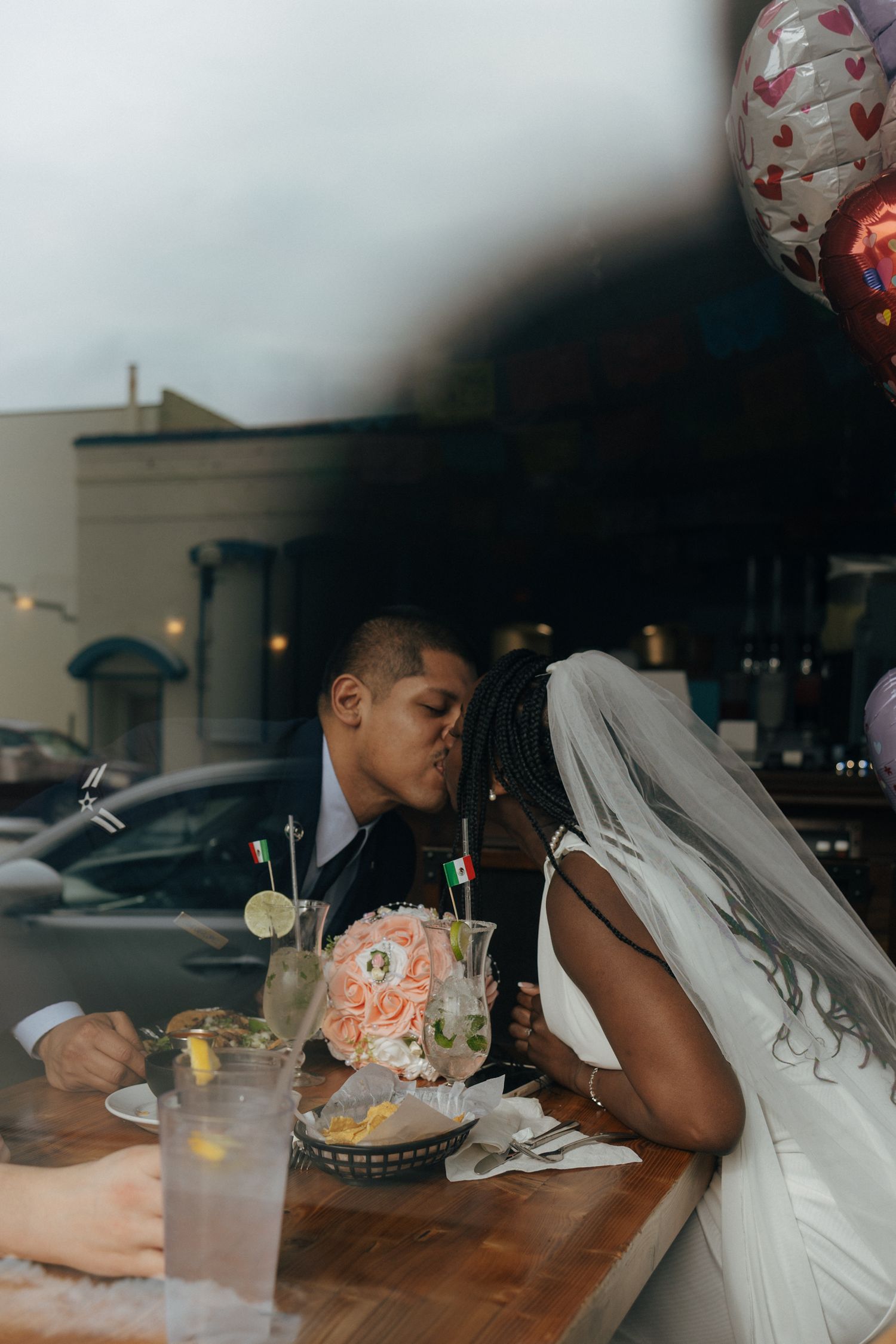Candid reception moment of dining and celebrating at a wooden table.