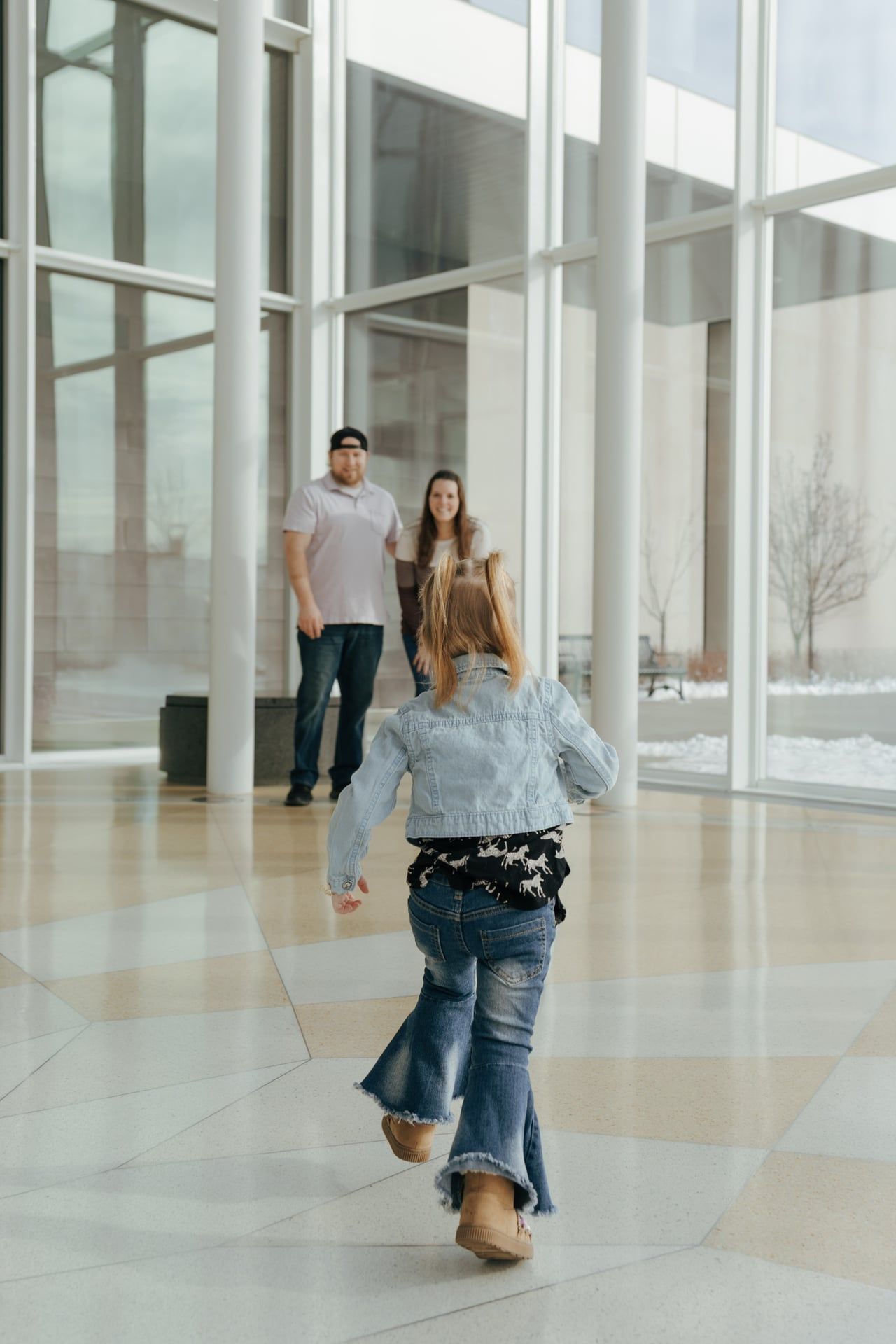 toddler running over to parents for family photos in Bismarck