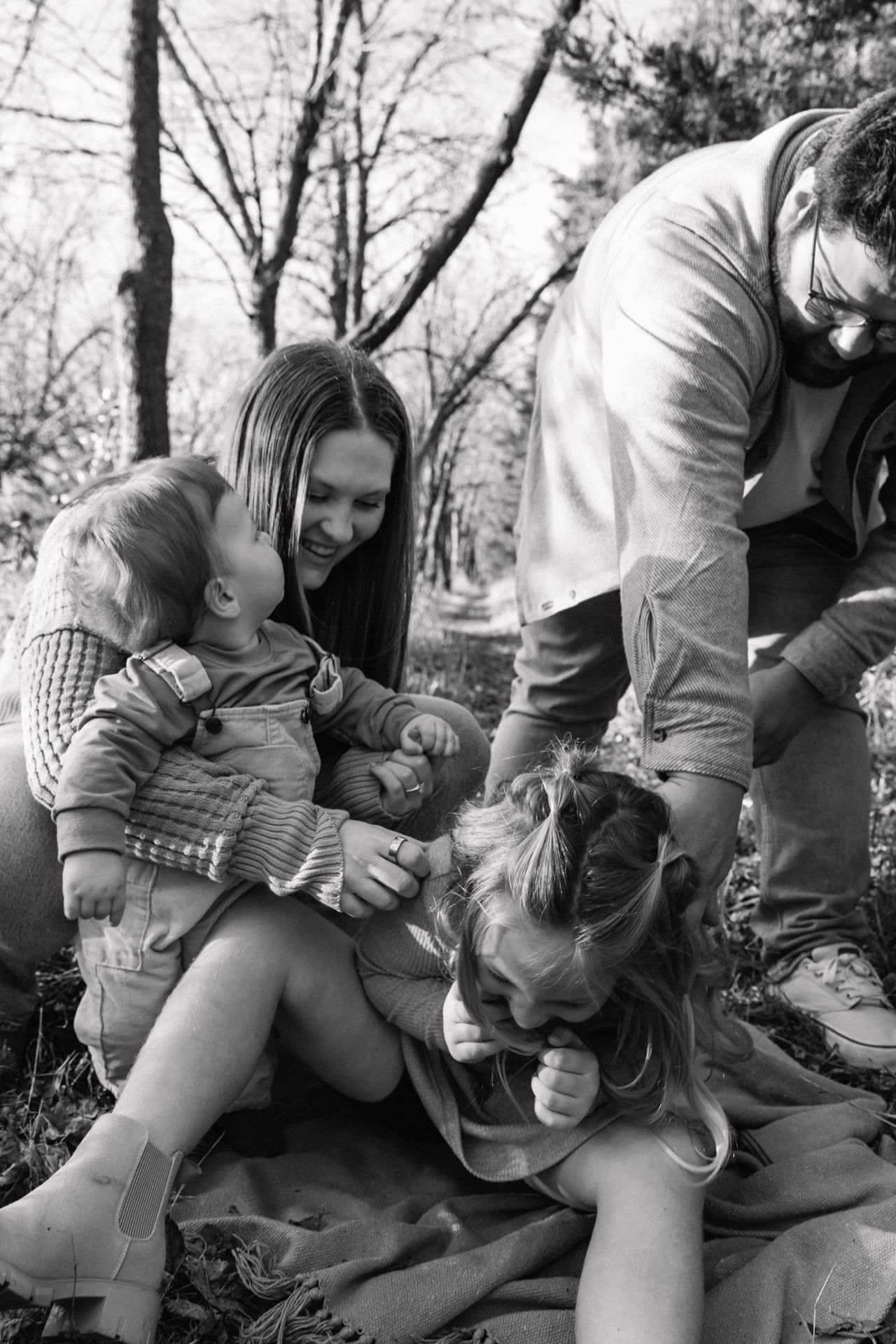 family photo session with parents tickling kids