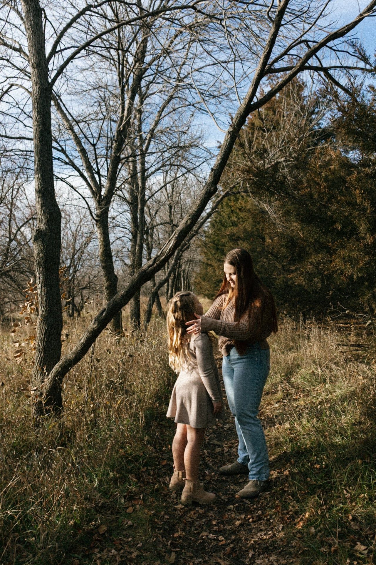 mom holding cheeks of daughter and kissing head