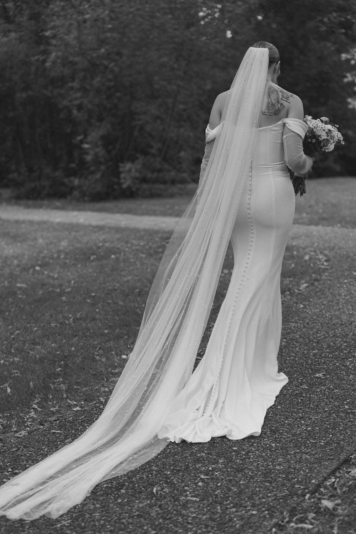 Bride walking to first look with groom on capitol grounds in Bismarck
