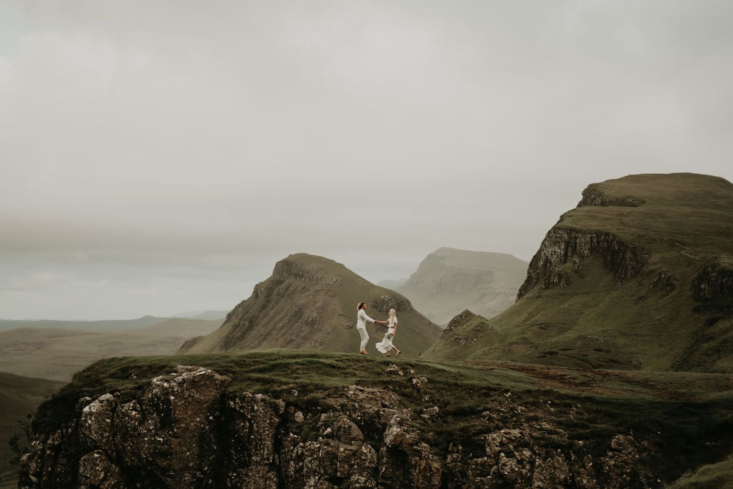 A dramatic wedding photo captured on misty cliffs in the Scottish highlands in Isle of Skye Scotland.
