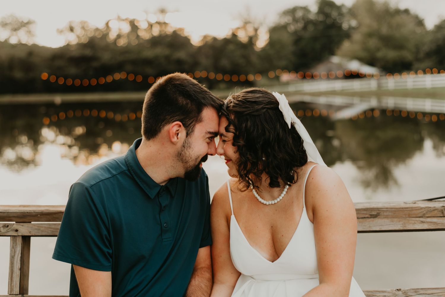 A romantic couple shares tender moments along a scenic lake at sunset under warm lighting conditions.