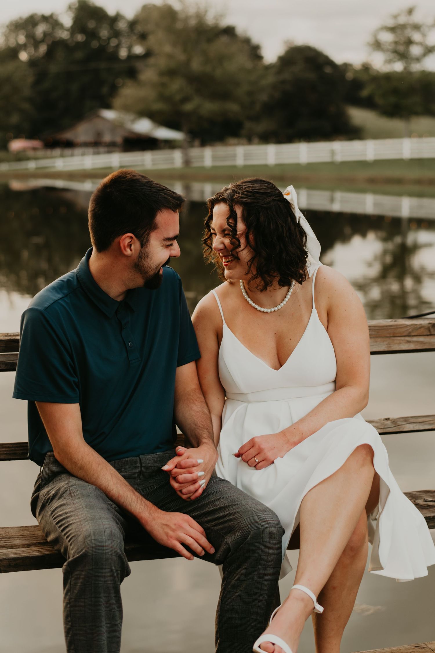 A romantic photoshoot session on a wooden dock by a serene lake at sunset.
