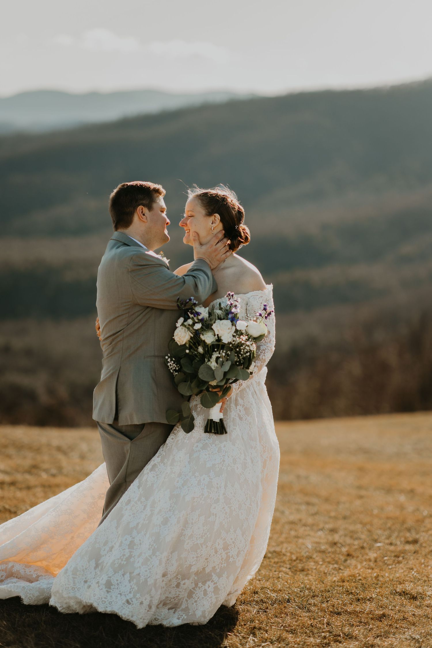 Newlyweds share tender moment on hillside during golden hour in North Carolina.
