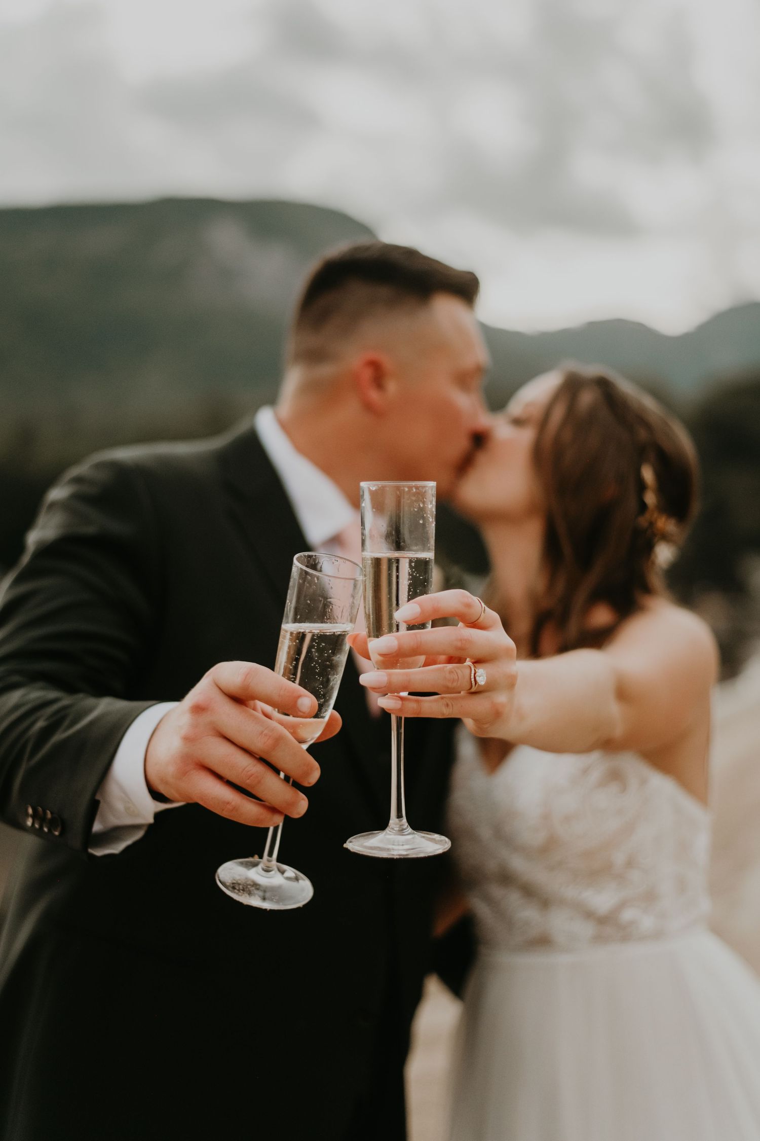 Intimate wedding toast with champagne glasses during sunset mountain ceremony in North Carolina.