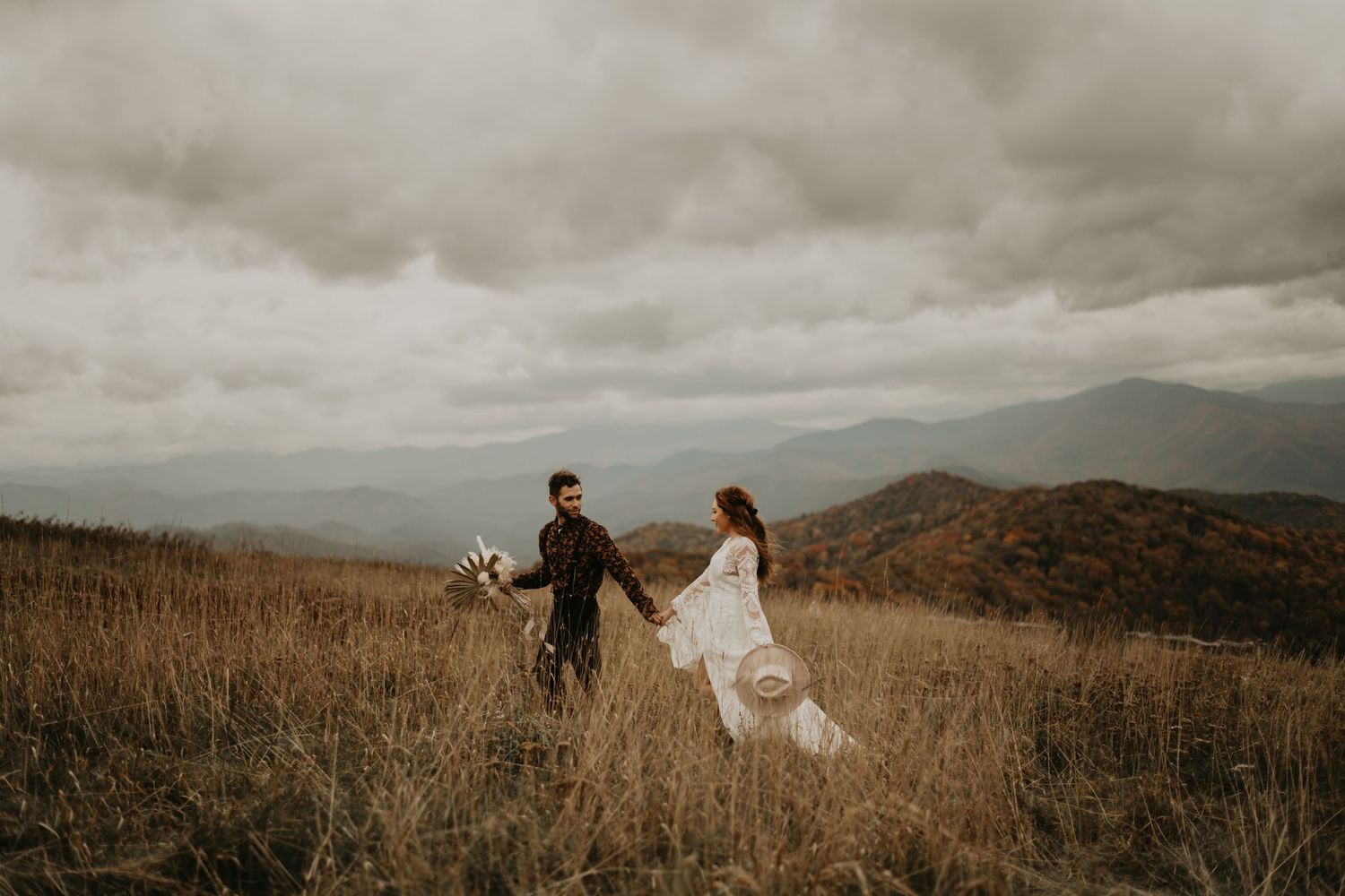 Dramatic cloudy mountain landscape provides epic setting for destination wedding portraits.