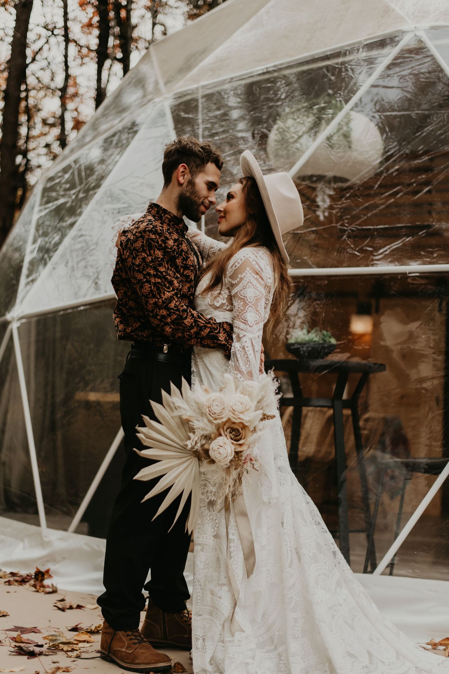 Stylish autumn wedding photoshoot with pampas grass bouquet and transparent umbrellas.