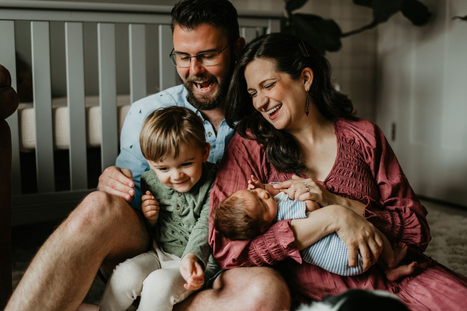 Intimate family moment shared on bed with newborn in candid indoor setting in Asheville North Carolina