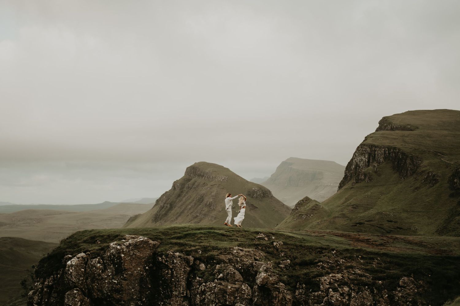 Moody landscape panorama of misty mountains and rolling hills beneath dramatic cloudy skies in isle of Skye Scotland.