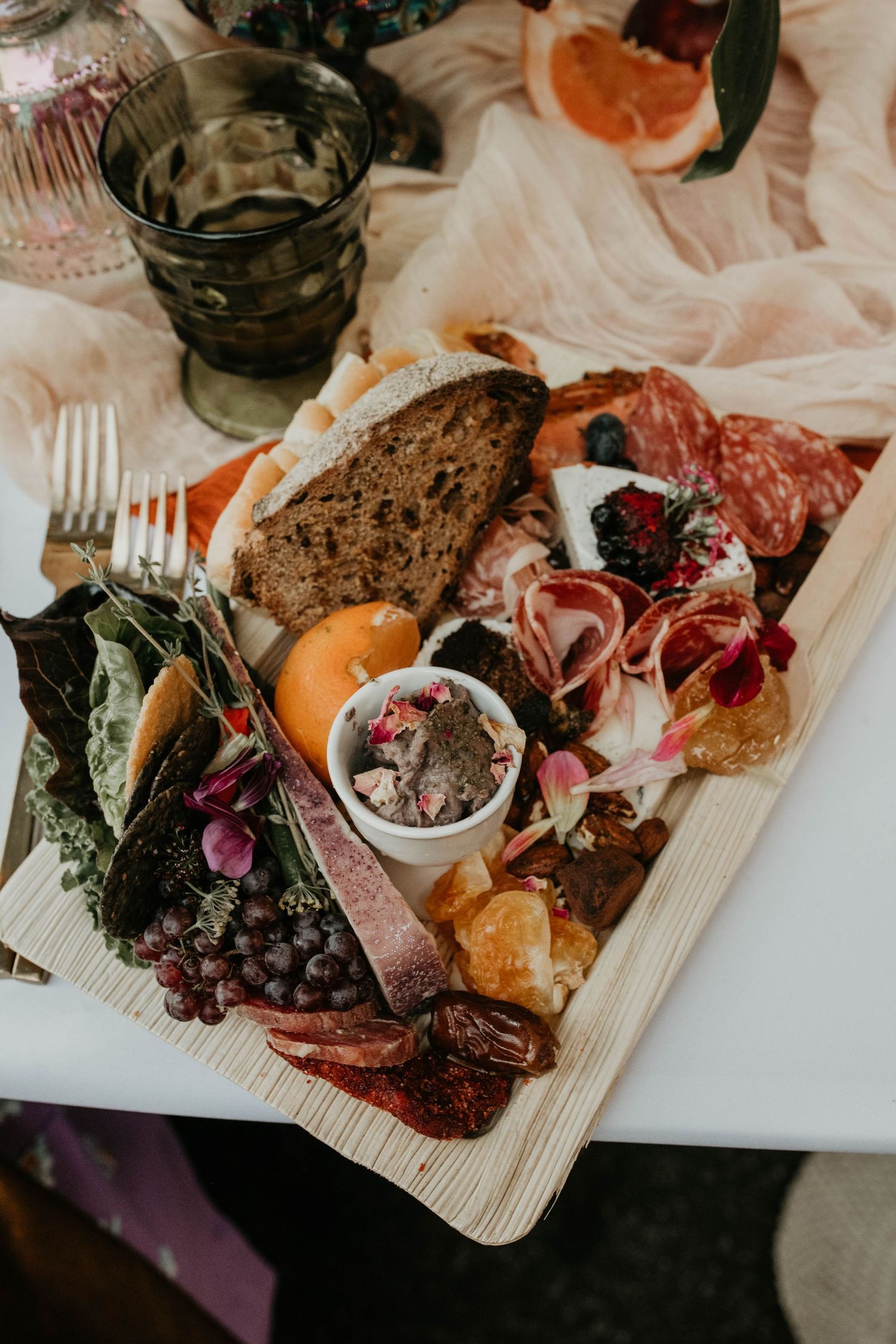 Gourmet charcuterie board with meats, cheeses, and fruits on wooden serving platter.