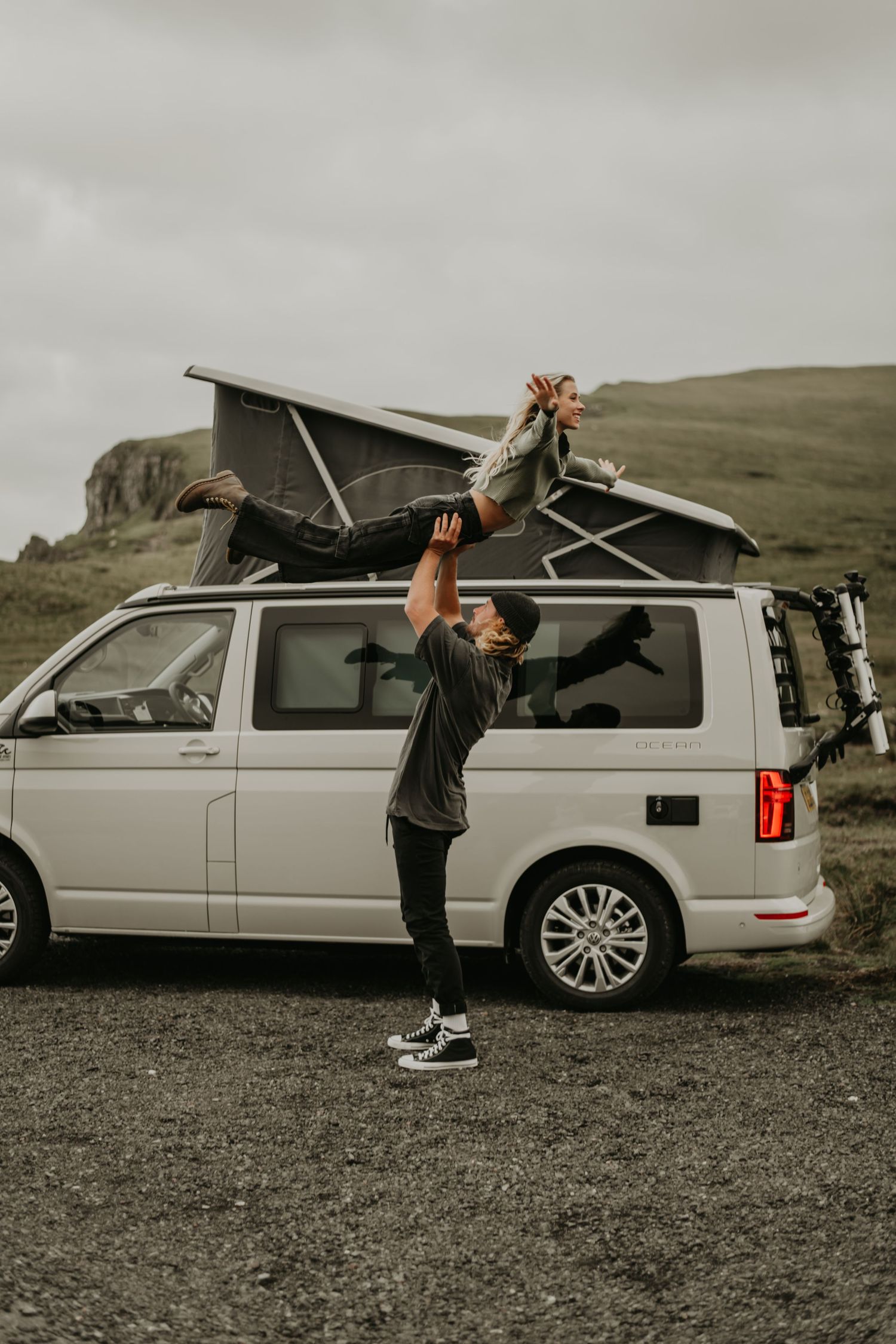 A dynamic sequence shows a person demonstrating how to open and extend a car's rooftop sunroof panel on a gray SUV.