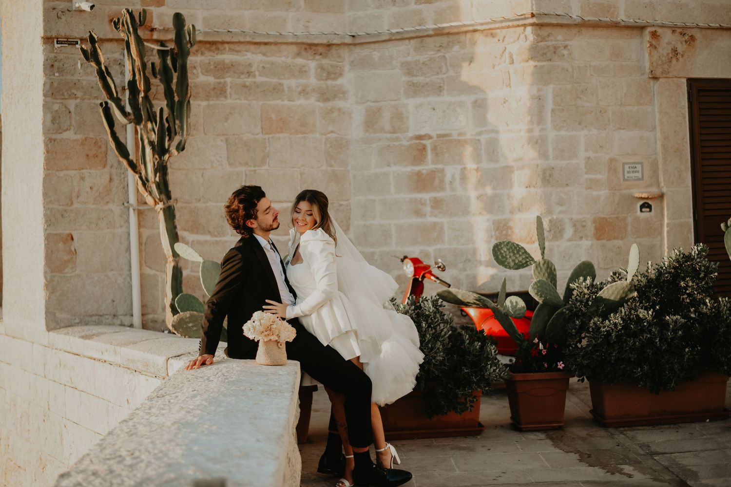 A romantic moment captured between newlyweds near a Mediterranean courtyard with cactus plants in Monopoli Italy.