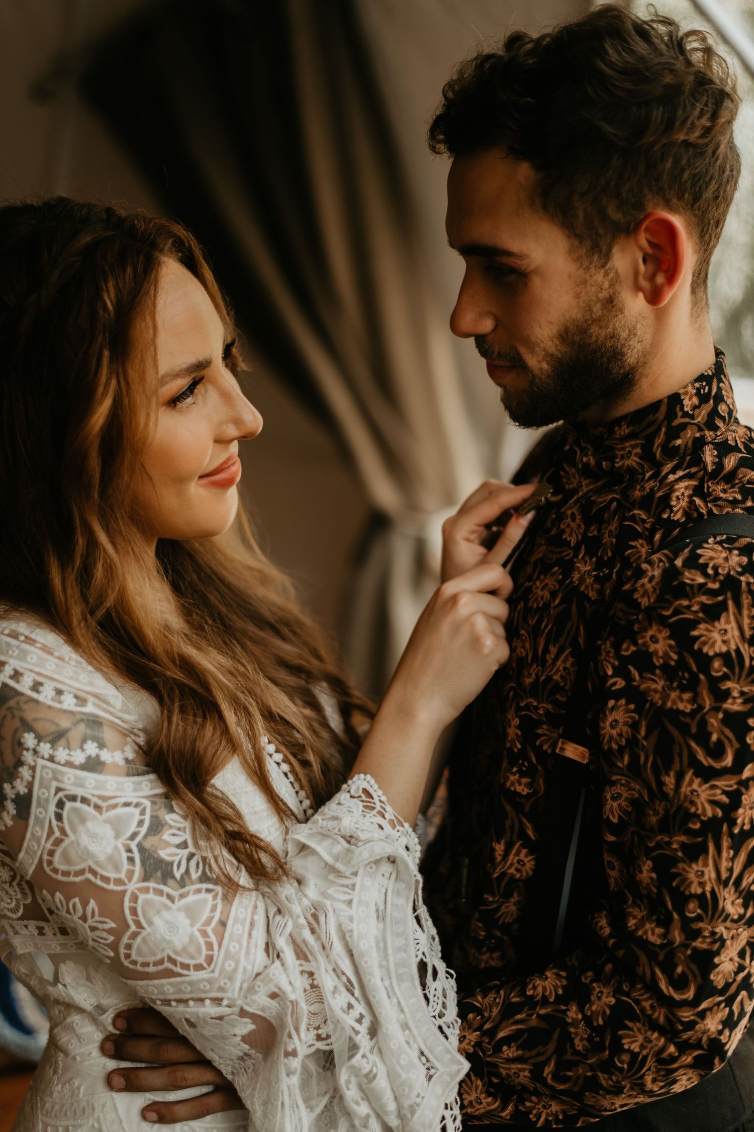 Intimate wedding moment captured in warm tones with boho-styled decor and vintage furnishings.