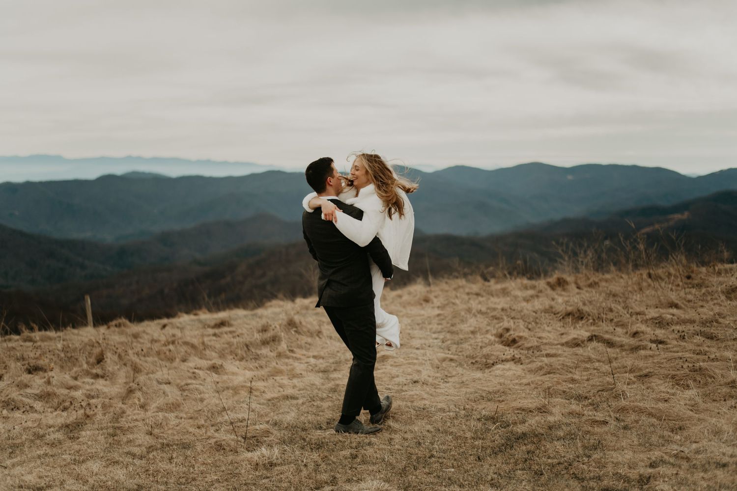 Dramatic mountain wedding photography with couple silhouetted against sweeping valley vista in North Carolina.