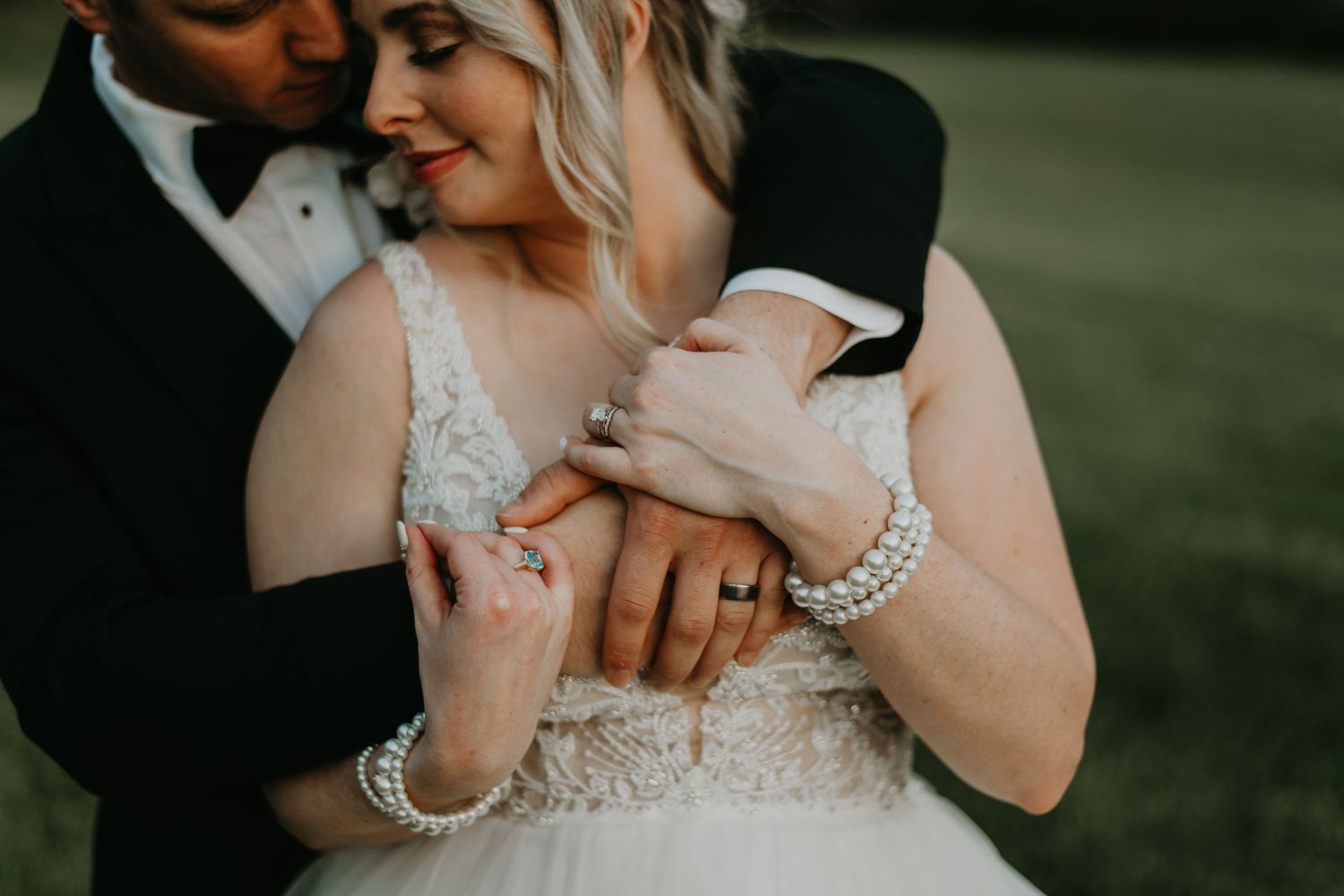 Close-up shot showing wedding dress details and jewelry during intimate moment.