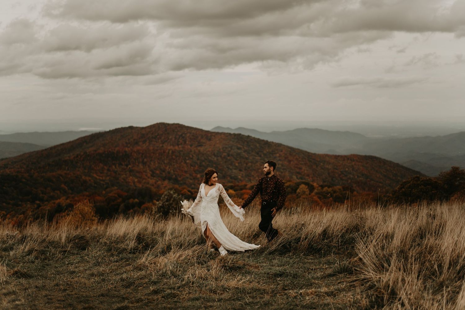 Dramatic mountain landscape serves as backdrop for wedding photos in late autumn in North Carolina.