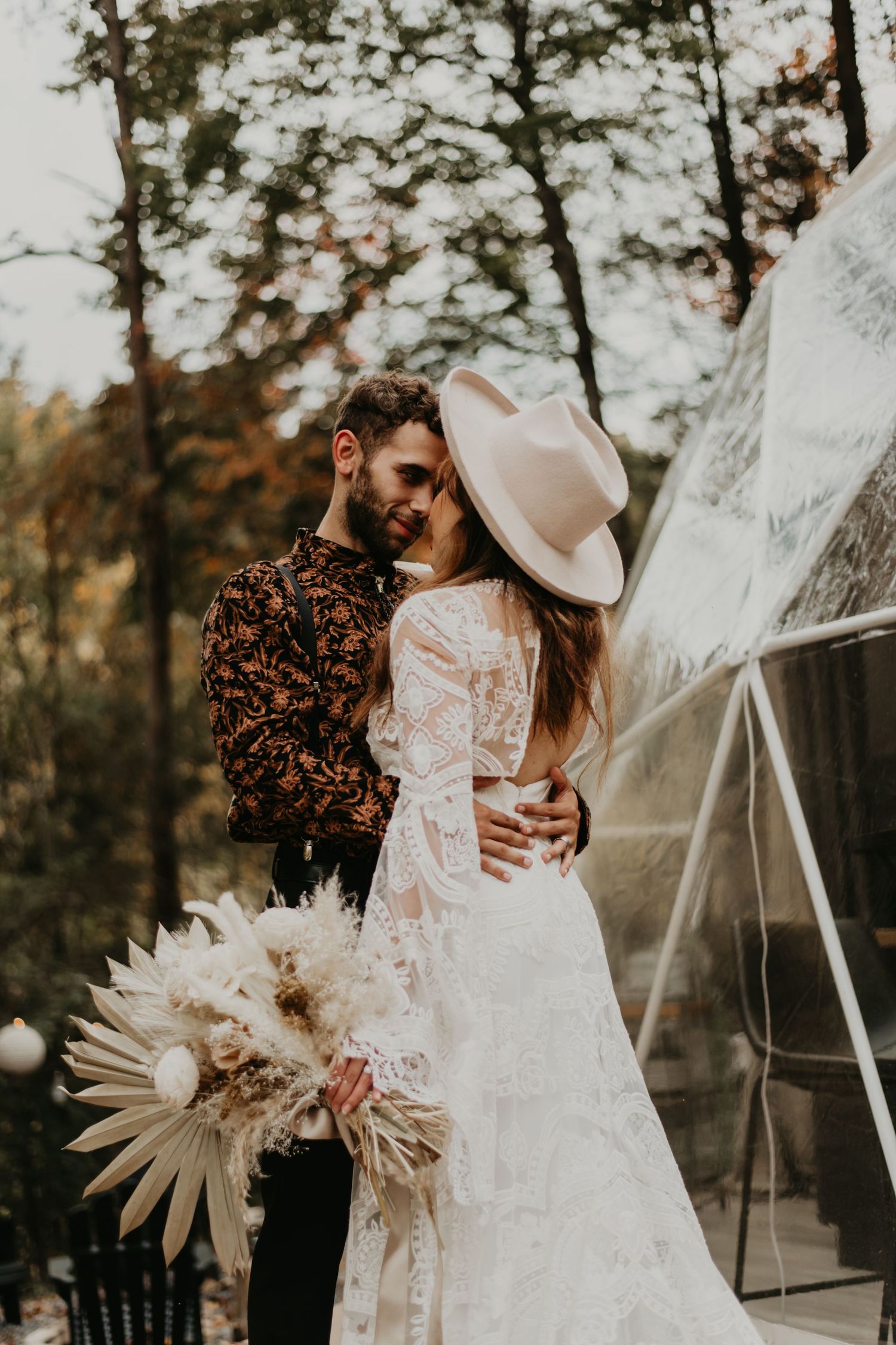 Artistic wedding photography featuring dried palm bouquet and white lace dress details.