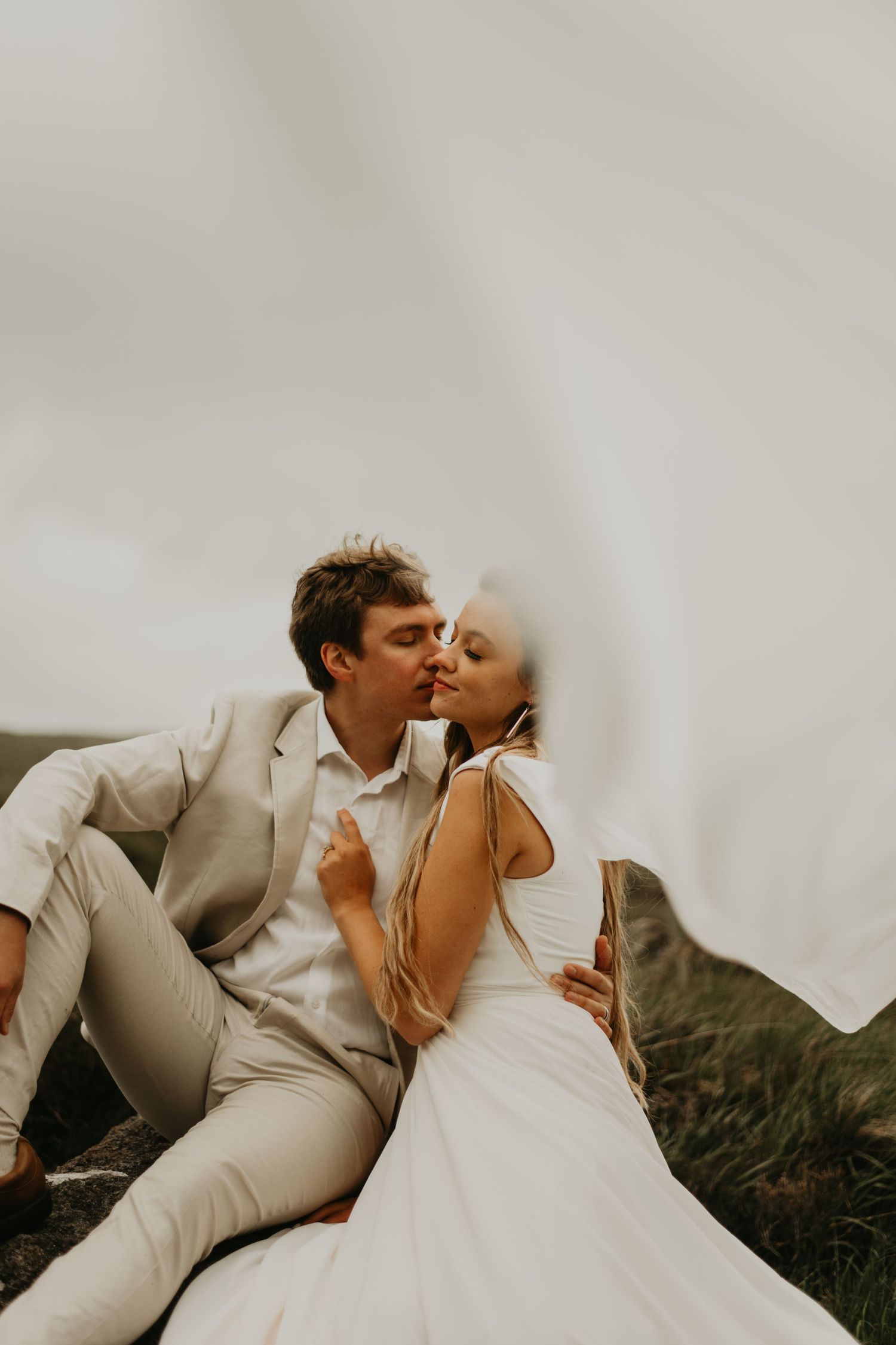 A romantic wedding photoshoot series featuring a couple in white and beige attire embracing in an outdoor setting.