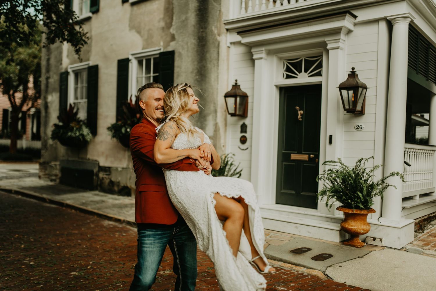 Couple sharing romantic moment outside classic white colonial style building in Charleston south Carolina.
