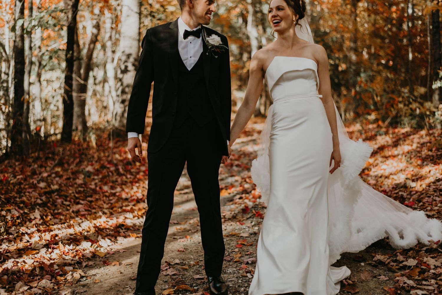 Autumn forest wedding portrait with fallen leaves and sunlight filtering through trees in North Carolina.