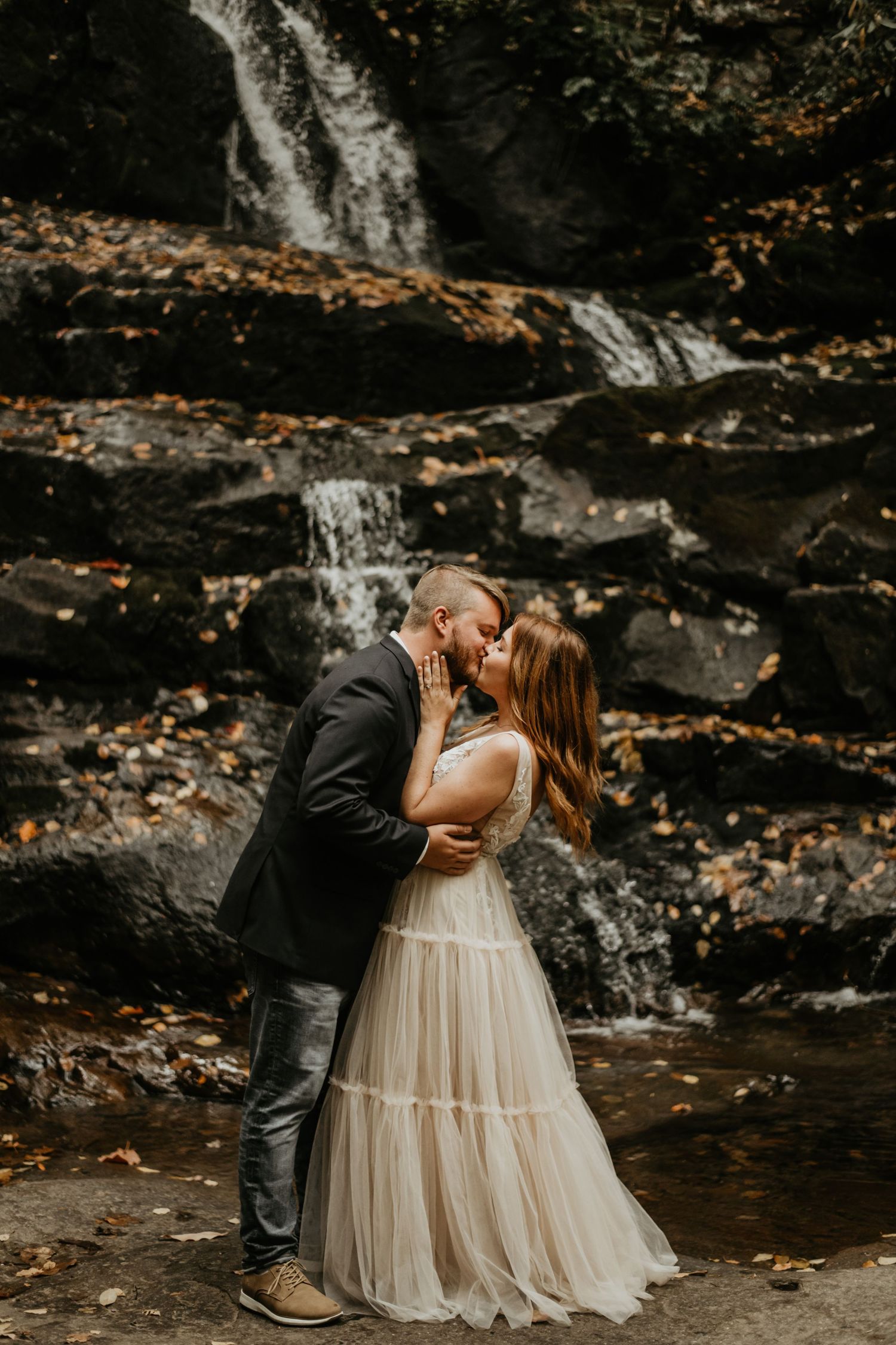Romantic waterfall wedding photo shoot with couple in formal attire.
