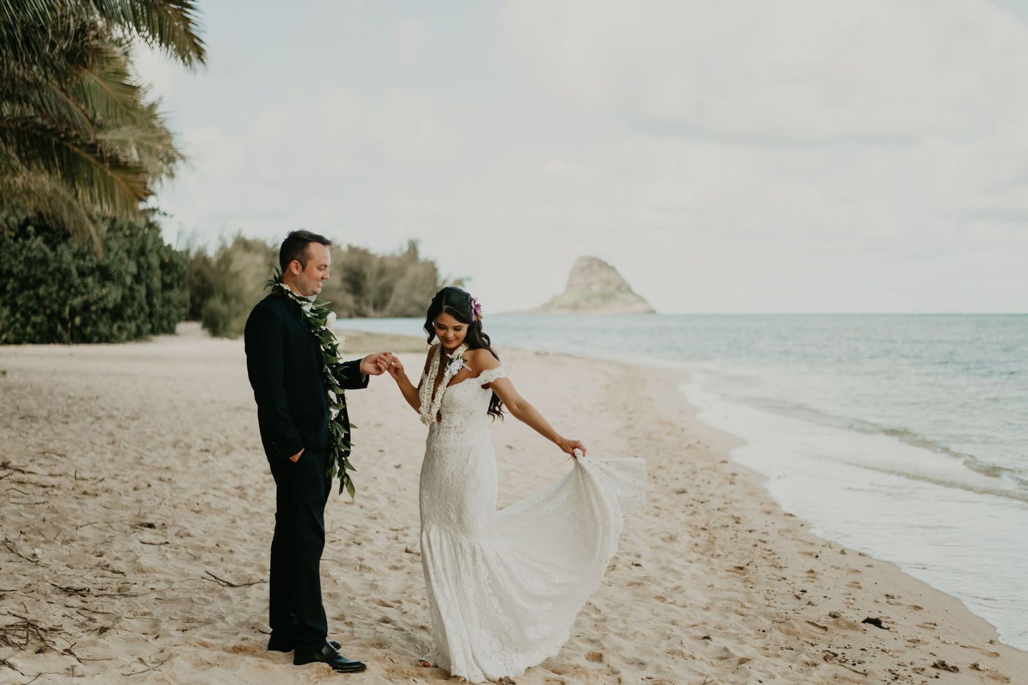 A romantic beach wedding moment with palm trees and ocean views in Hawaii.