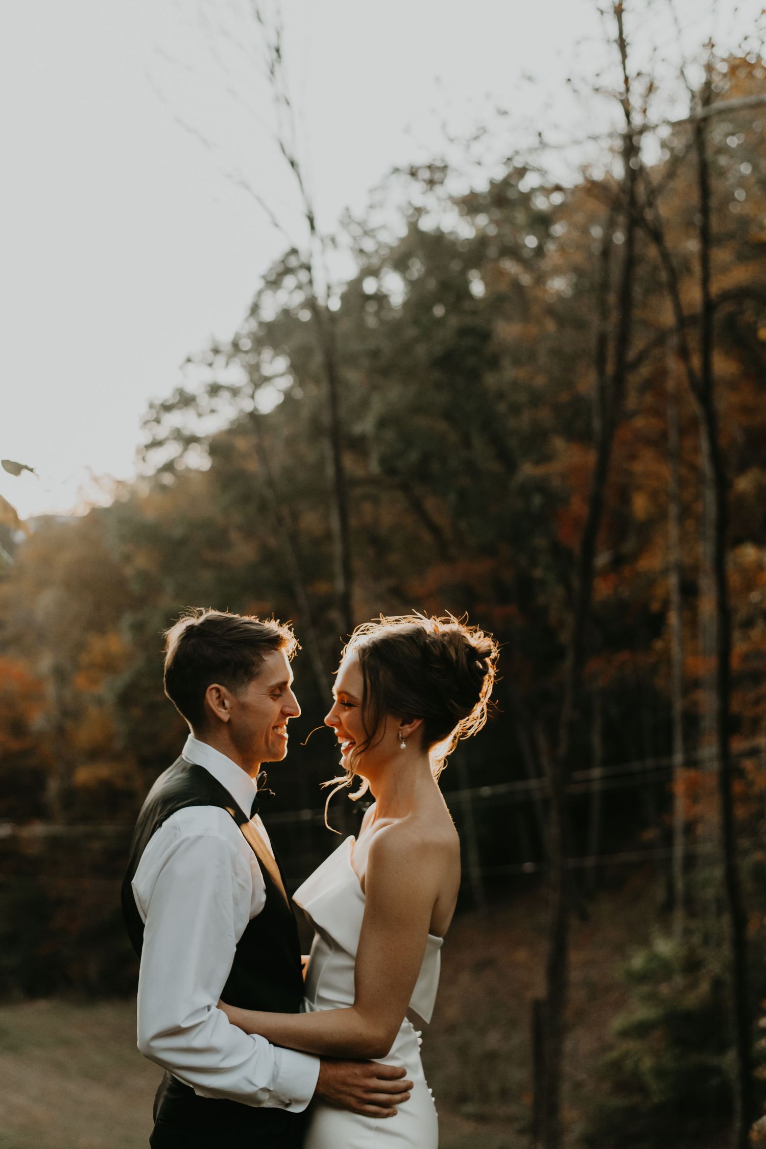 Romantic sunset moment between newlyweds in autumn forest setting in North Carolina