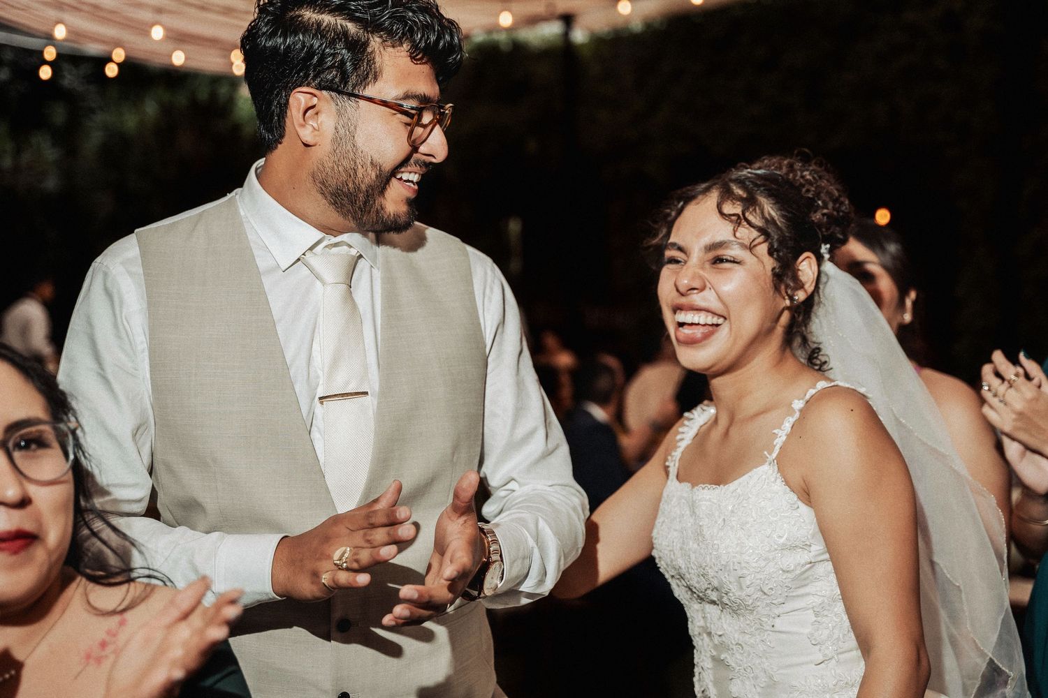 A joyful couple share a candid laugh together during their wedding reception celebration.