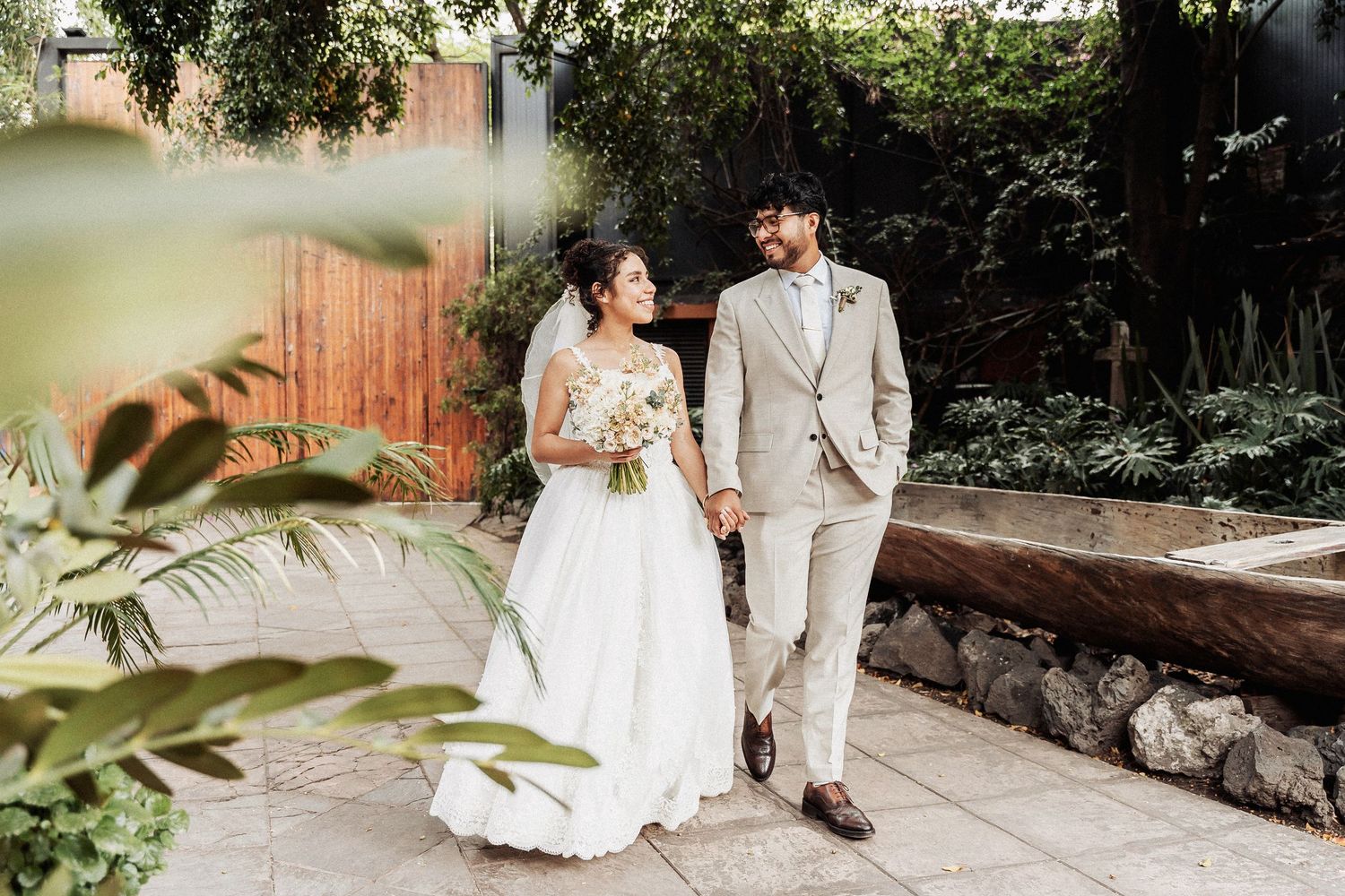 Romantic outdoor wedding photos taken in a lush garden setting with natural lighting.